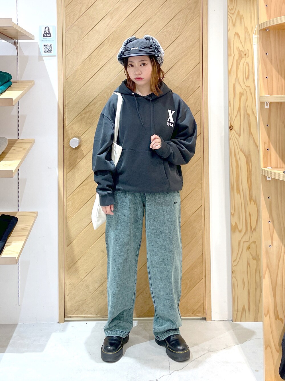 グリーン系のスウェットパンツ、ブラック系のブーツ、グレー系のパーカーを着用したレディースの秋コーディネートの1枚目の写真