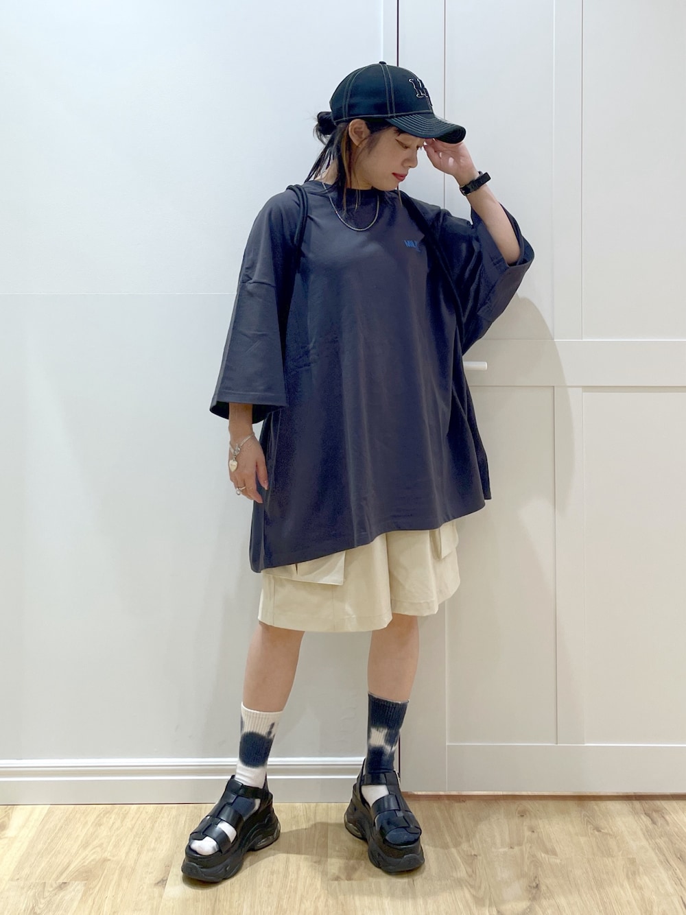 ブラック系のサンダル、グレー系のTシャツ/カットソー、ブラック系のバックパック/リュックを着用したレディースの夏コーディネートの1枚目の写真