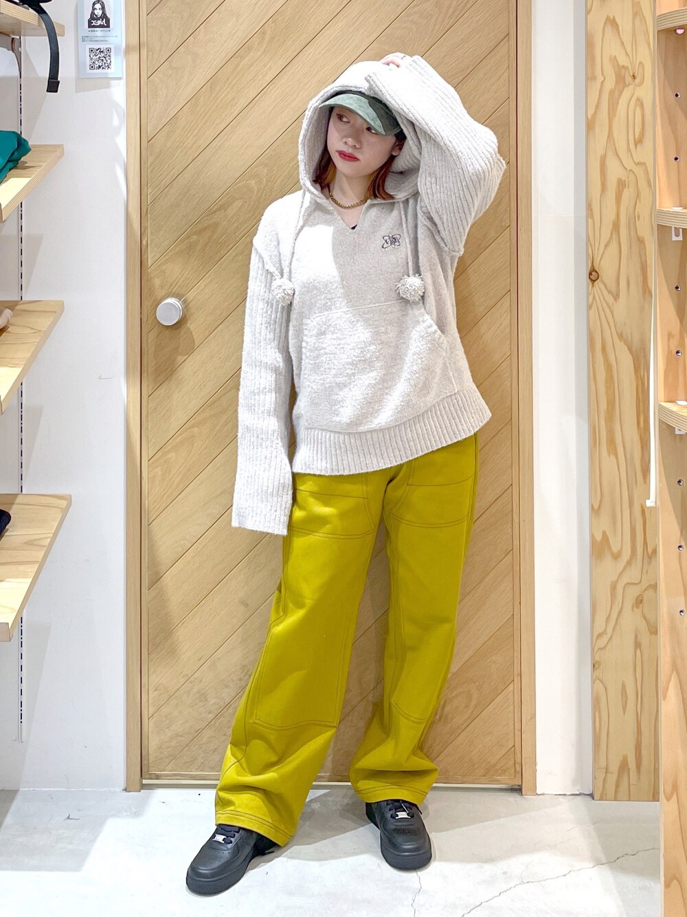 ブラウン系のその他パンツ、ブラック系のスニーカー、ホワイト系のニット/セーターを着用したレディースの秋コーディネートの1枚目の写真