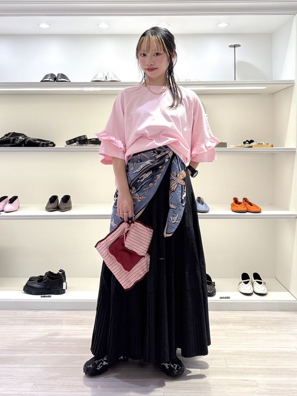 ピンク系のTシャツ/カットソー、ブラック系のスカート、ブラック系のスニーカーを着用したレディースの夏コーディネートの1枚目の写真