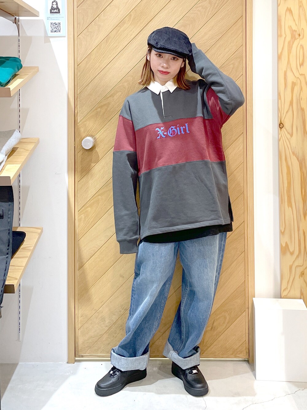 ブルー系のデニムパンツ、ブラック系のスニーカー、グレー系のスウェットを着用したレディースの秋コーディネートの1枚目の写真