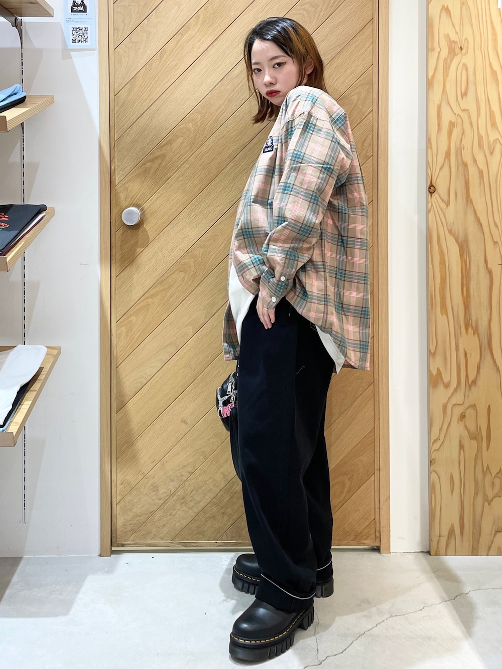 ブラック系のブーツ、ブラック系のデニムパンツ、グレー系のシャツ/ブラウスを着用したレディースの秋コーディネートの1枚目の写真