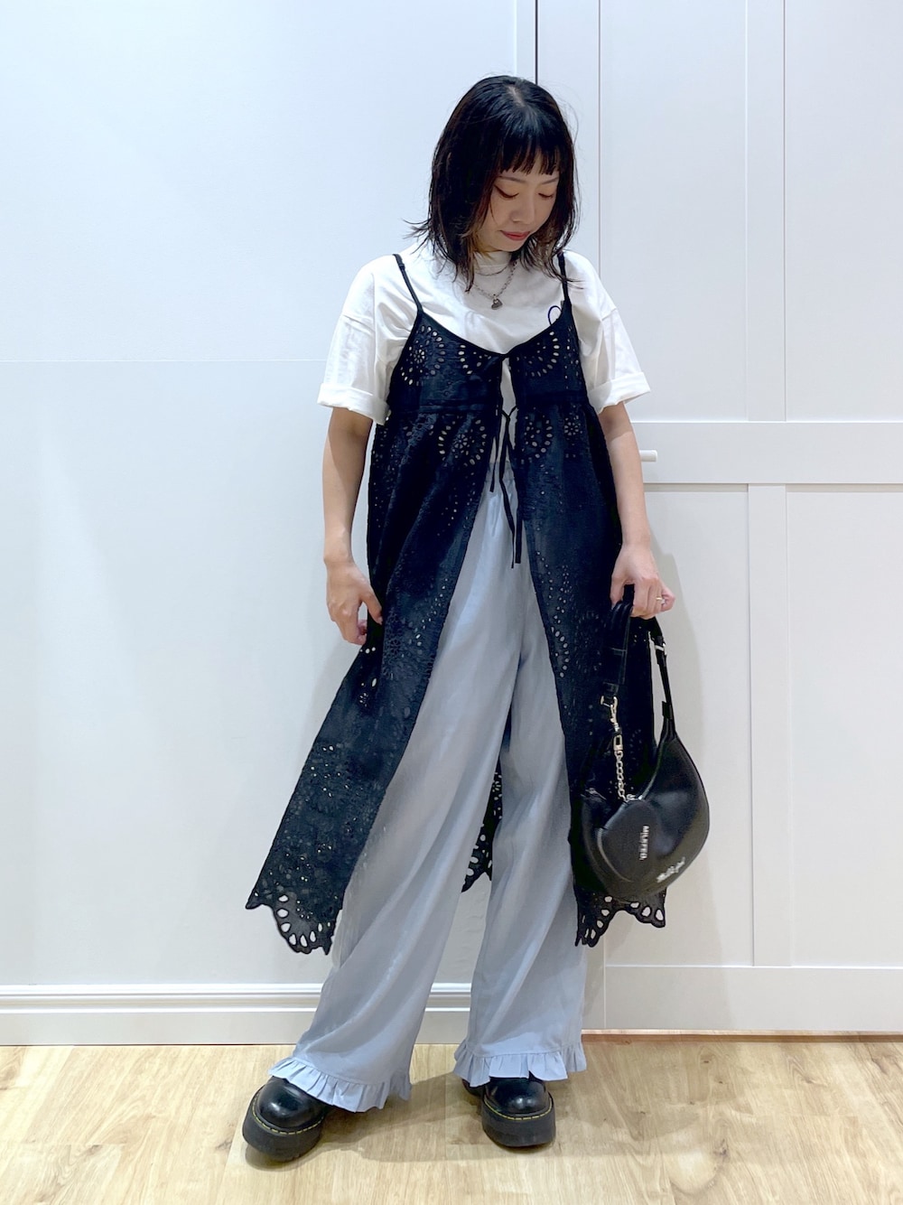 ブルー系のその他パンツ、ブラック系のブーツ、ブラック系のハンドバッグを着用したレディースの夏コーディネートの1枚目の写真