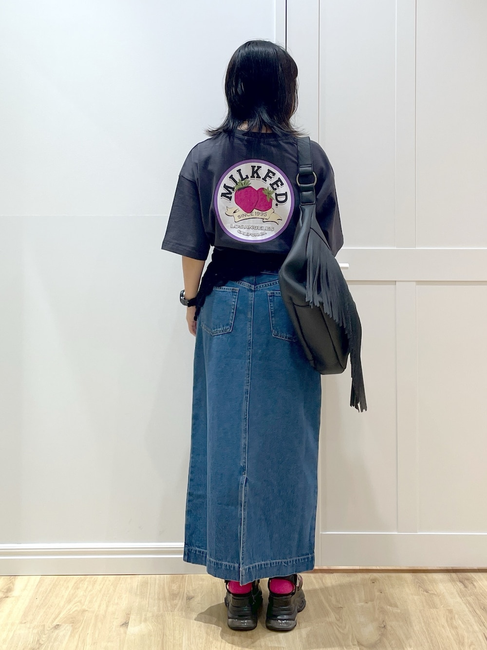 ブラック系のショルダーバッグ、グレー系のTシャツ/カットソー、ブルー系のデニムスカートを着用したレディースの夏コーディネートの1枚目の写真