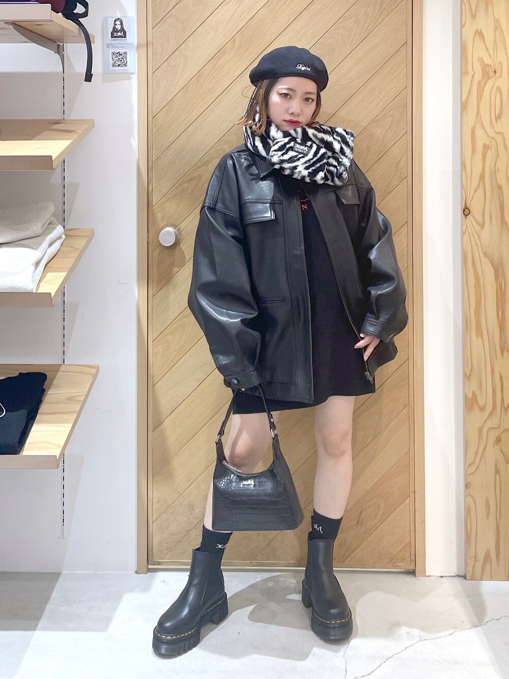 ブラック系のニット/セーター、ブラック系のライダースジャケット、ブラック系のハンドバッグを着用したレディースの秋コーディネートの1枚目の写真