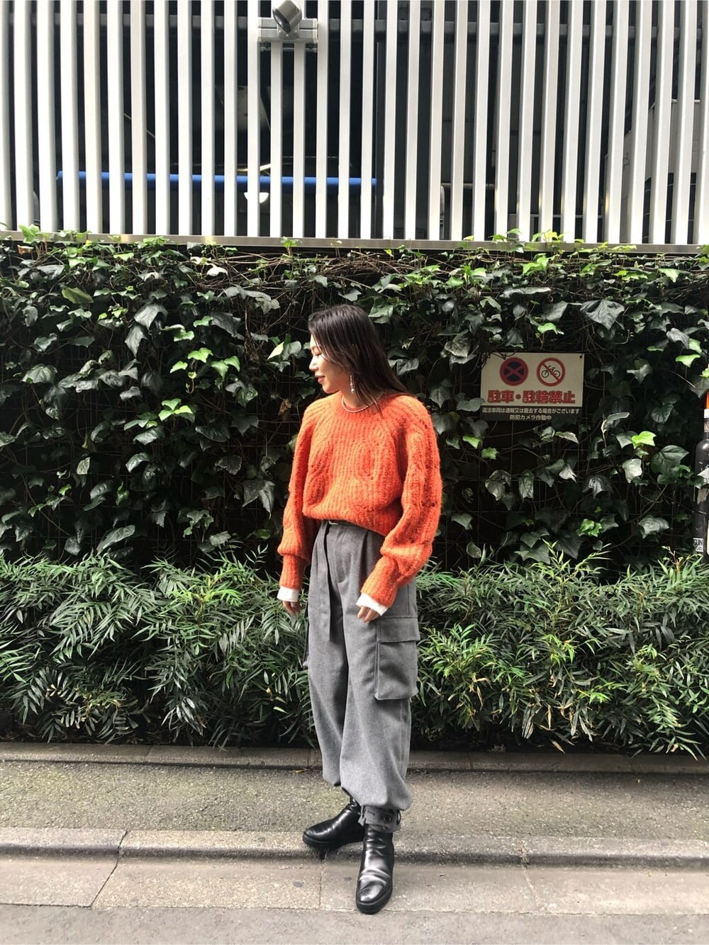 ホワイト系のTシャツ/カットソー、グレー系のカーゴパンツ、オレンジ系のニット/セーターを着用したレディースの秋コーディネートの1枚目の写真