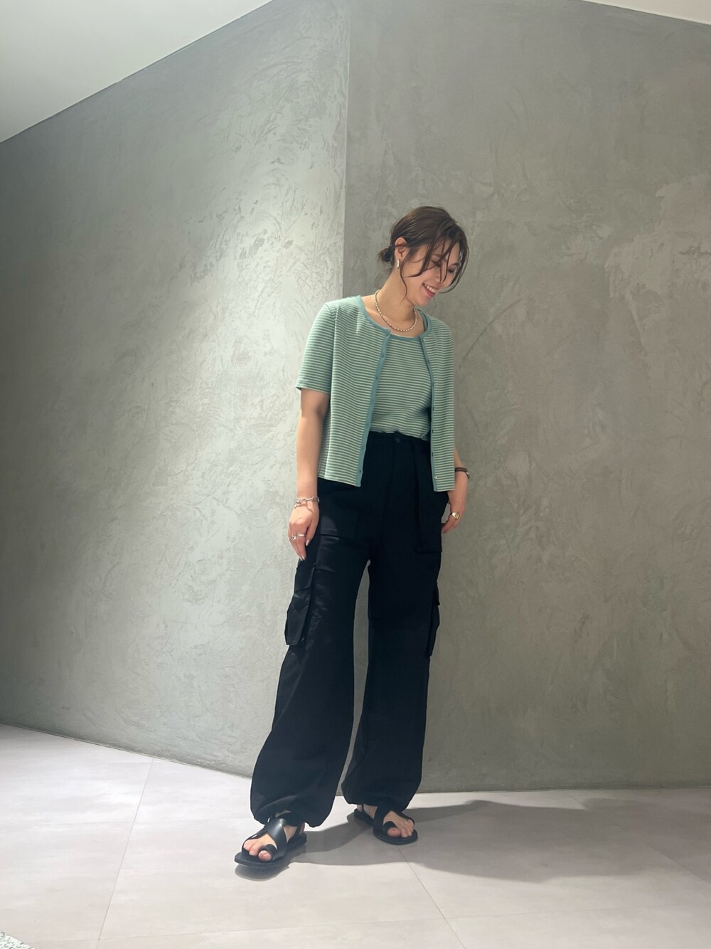 ブラック系のカーゴパンツ、イエロー系のキャミソールを着用したレディースの夏コーディネートの1枚目の写真