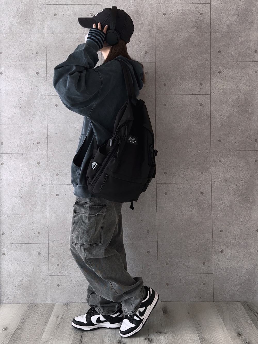 ブルー系のパーカー、グレー系のパンツ、ブラック系のスニーカーを着用したレディースの秋コーディネートの1枚目の写真