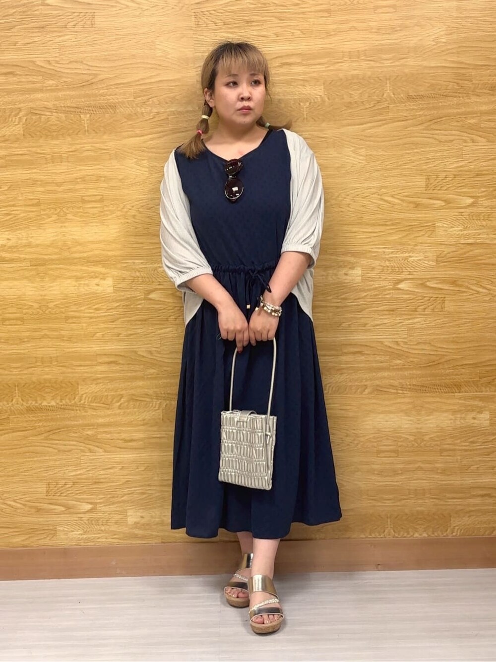 グレー系のカーディガン/ボレロ、ブルー系のワンピース、シルバー系のサンダルを着用したレディースの夏コーディネートの1枚目の写真