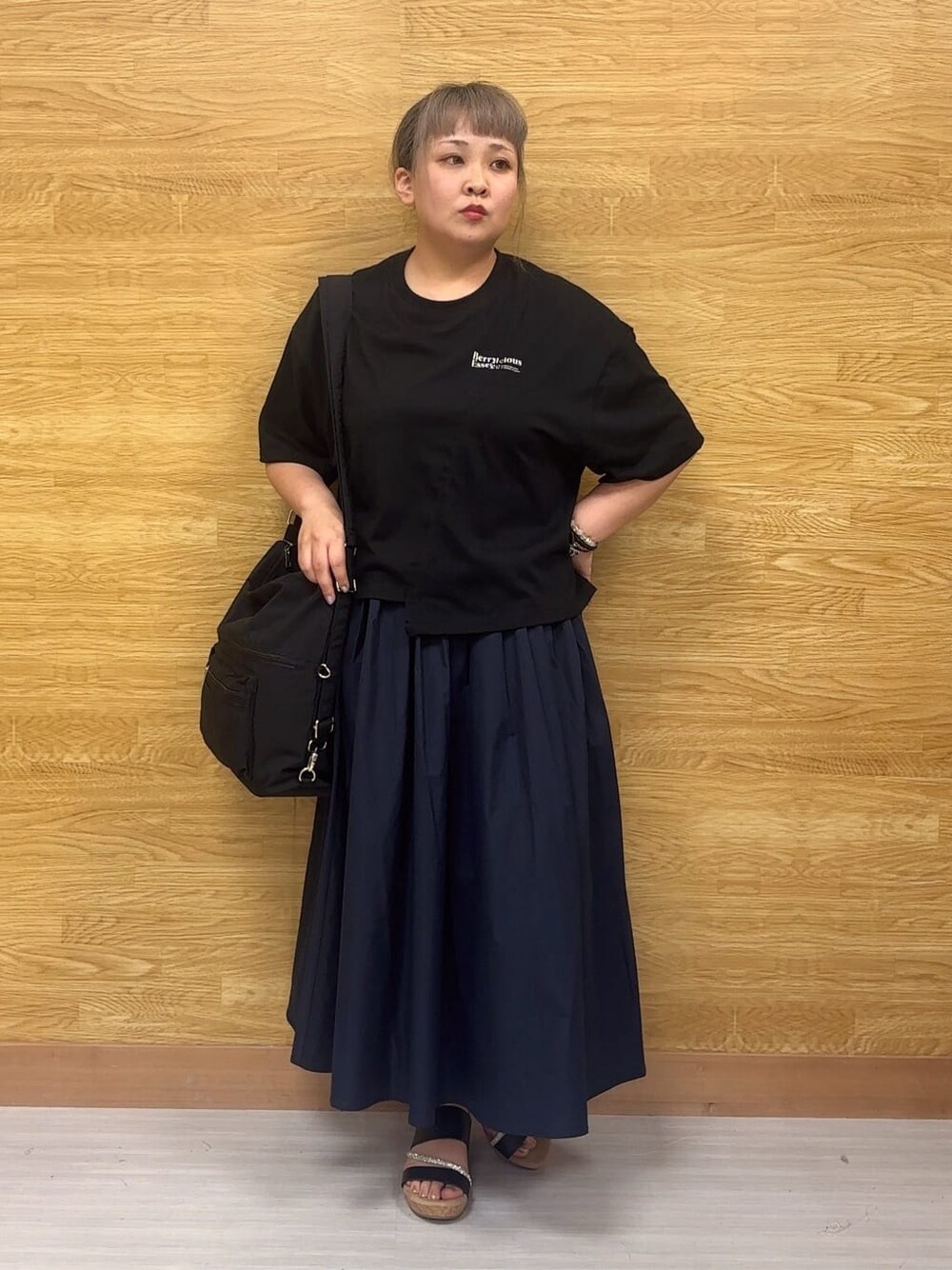 ブラック系のTシャツ/カットソー、ブルー系のスカート、ブラック系のサンダルを着用したレディースの夏コーディネートの1枚目の写真