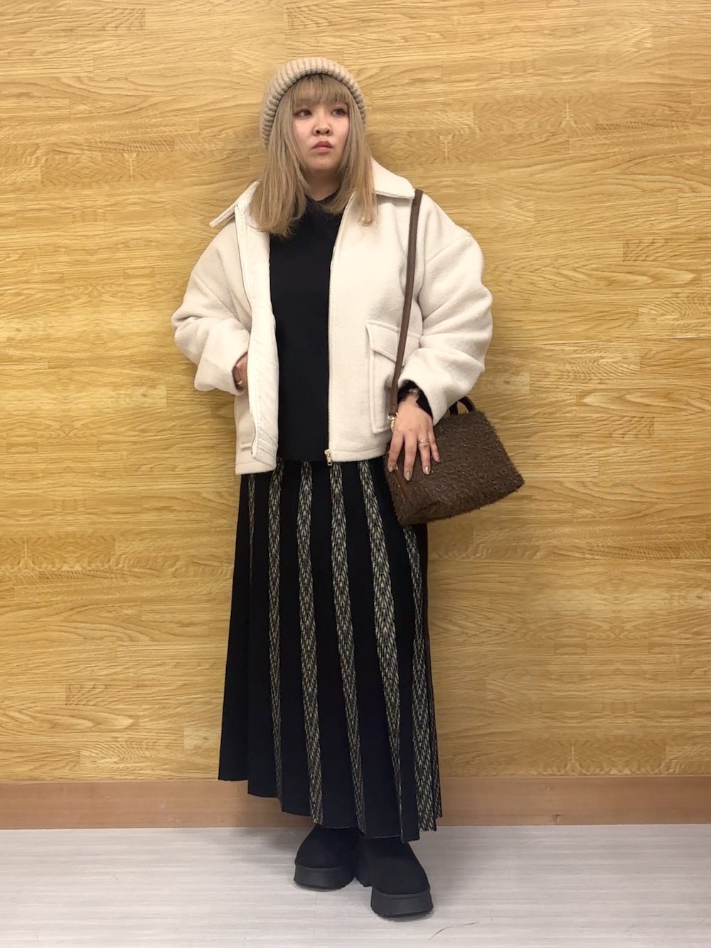 ホワイト系のブルゾン、ブラック系のスカート、ブラック系のニット/セーターを着用したレディースの秋コーディネートの1枚目の写真