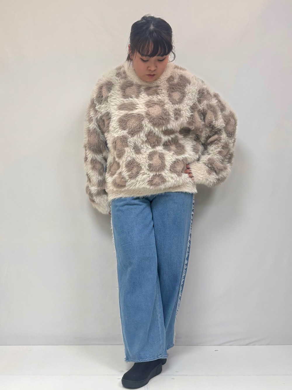 ベージュ系のニット/セーター、ブルー系のデニムパンツ、ブラック系のブーツを着用したレディースの冬コーディネートの1枚目の写真