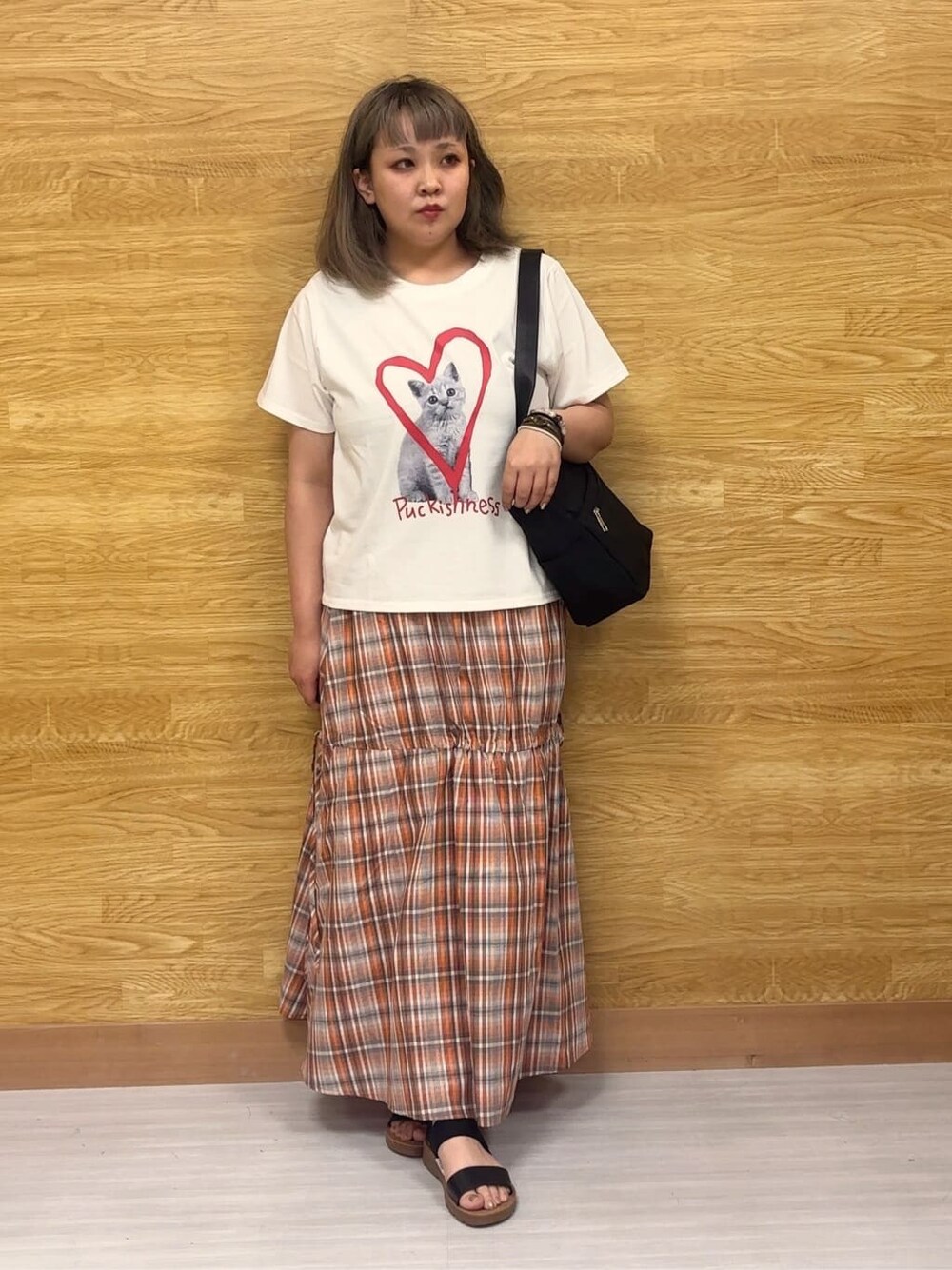 ホワイト系のTシャツ/カットソー、オレンジ系のスカート、ブラック系のサンダルを着用したレディースの夏コーディネートの1枚目の写真