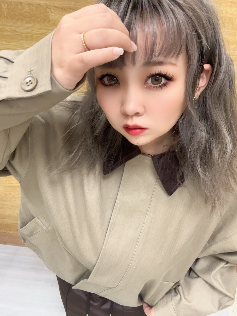 イエロー系のブルゾン、ブラウン系のスカートを着用したレディースの秋コーディネートの1枚目の写真