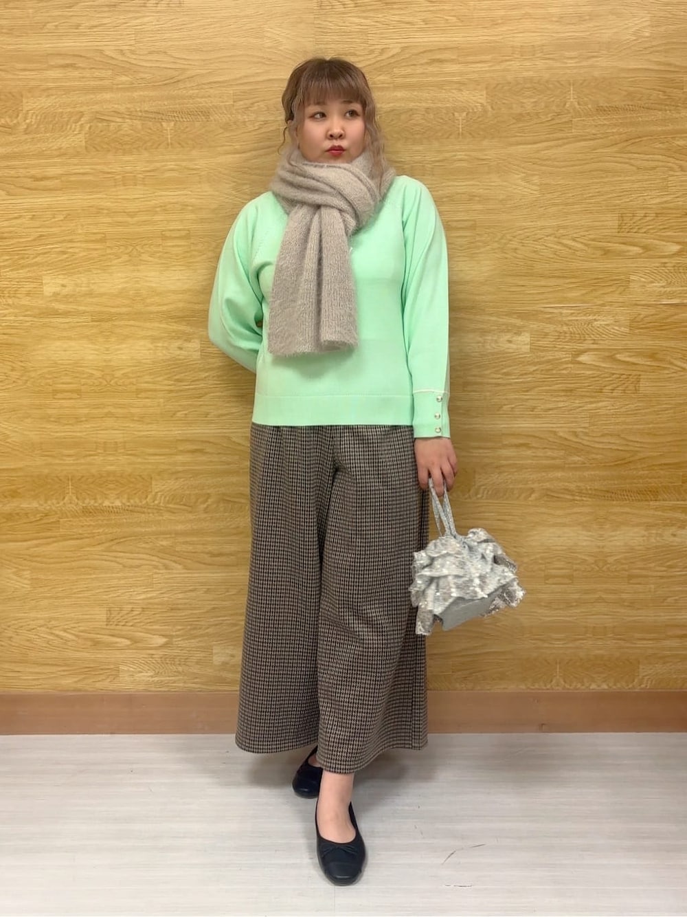 グリーン系のニット/セーター、ブラウン系のその他パンツ、ブラック系のその他シューズを着用したレディースの冬コーディネートの1枚目の写真