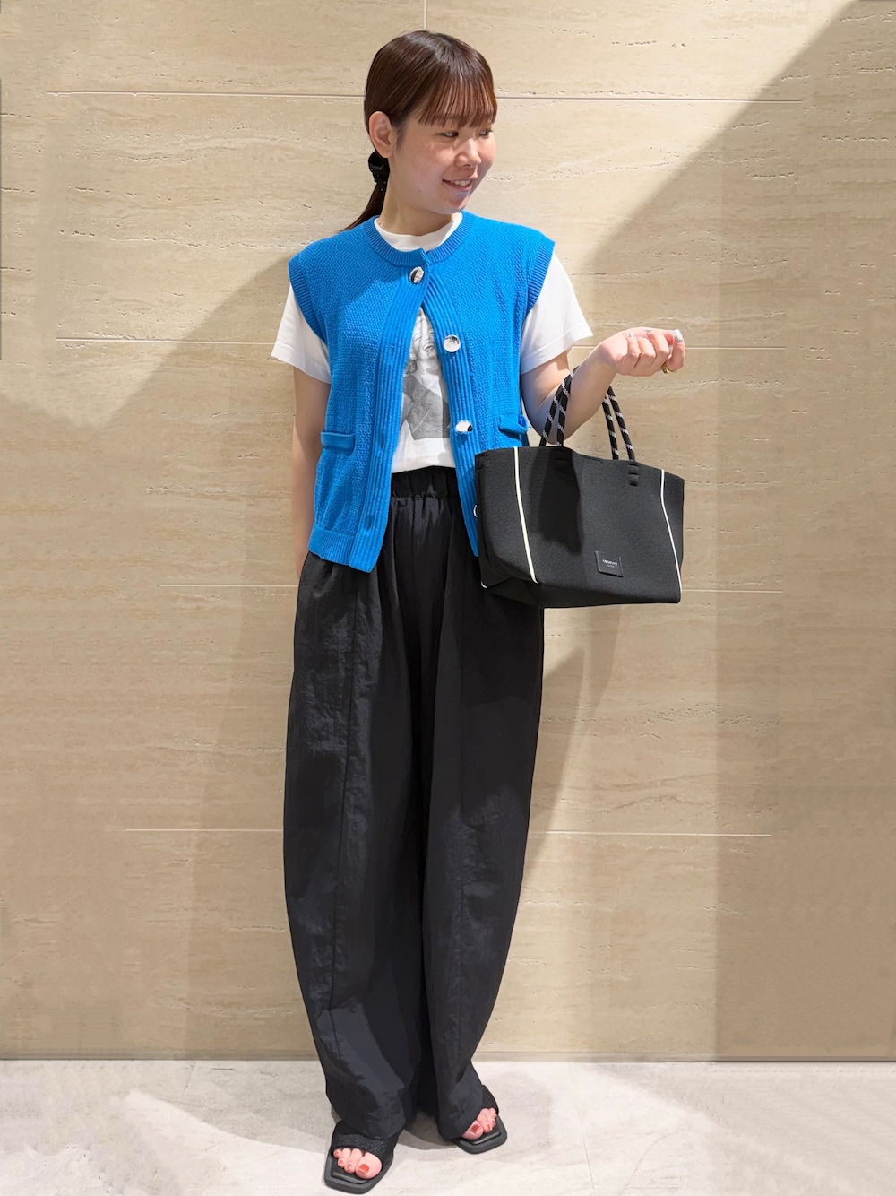 ブルー系のニット/セーター、ブラック系のその他パンツ、ブラック系のトートバッグを着用したレディースの夏コーディネートの1枚目の写真