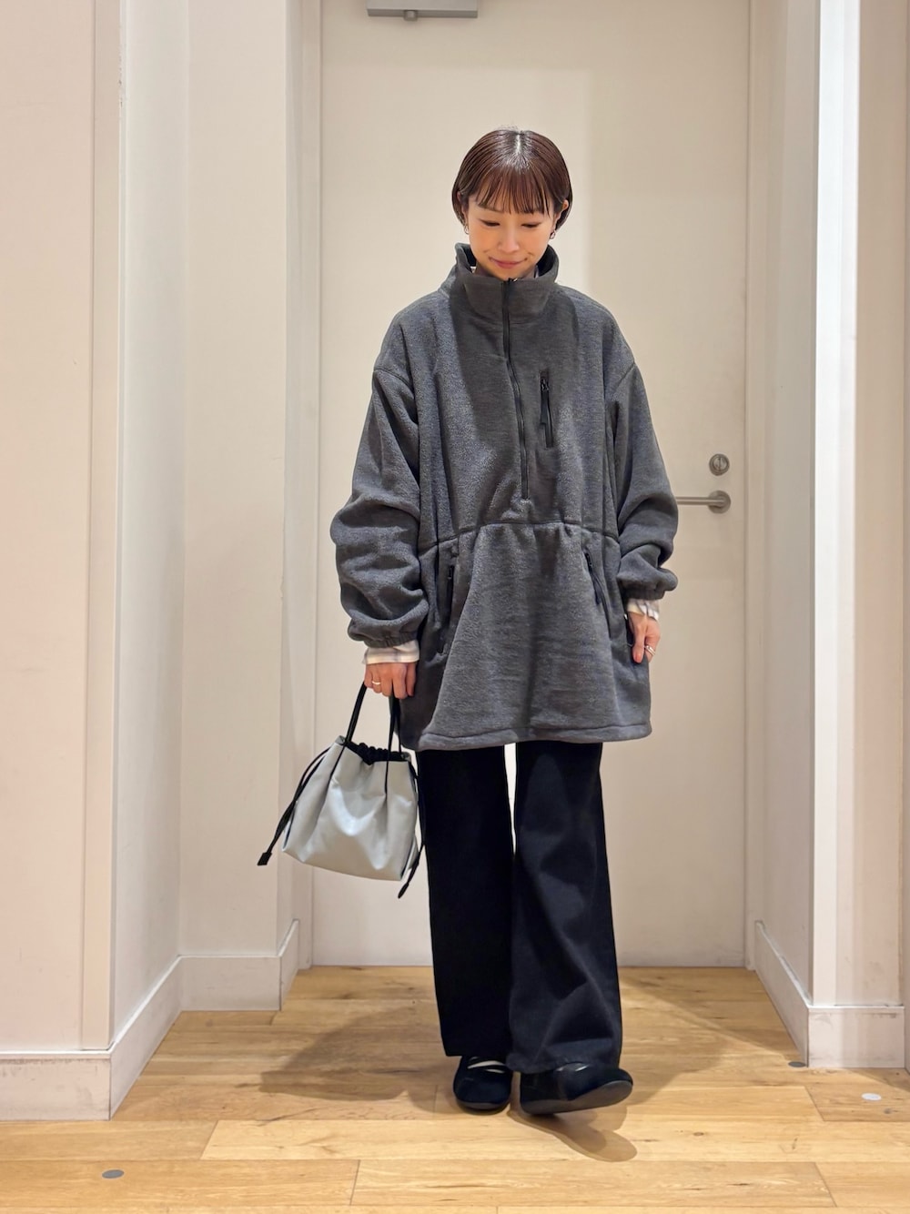 グレー系のスウェット、ブラック系のデニムパンツ、ホワイト系のシャツ/ブラウスを着用したレディースの秋コーディネートの1枚目の写真