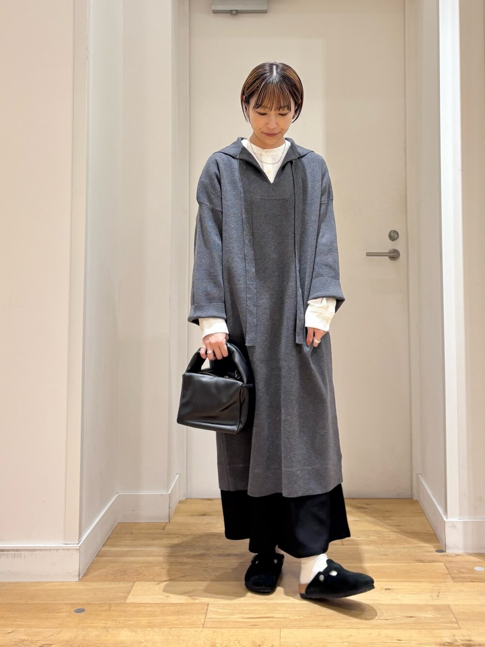 グレー系のワンピース、ホワイト系のシャツ/ブラウス、ブラック系のその他パンツを着用したレディースの秋コーディネートの1枚目の写真