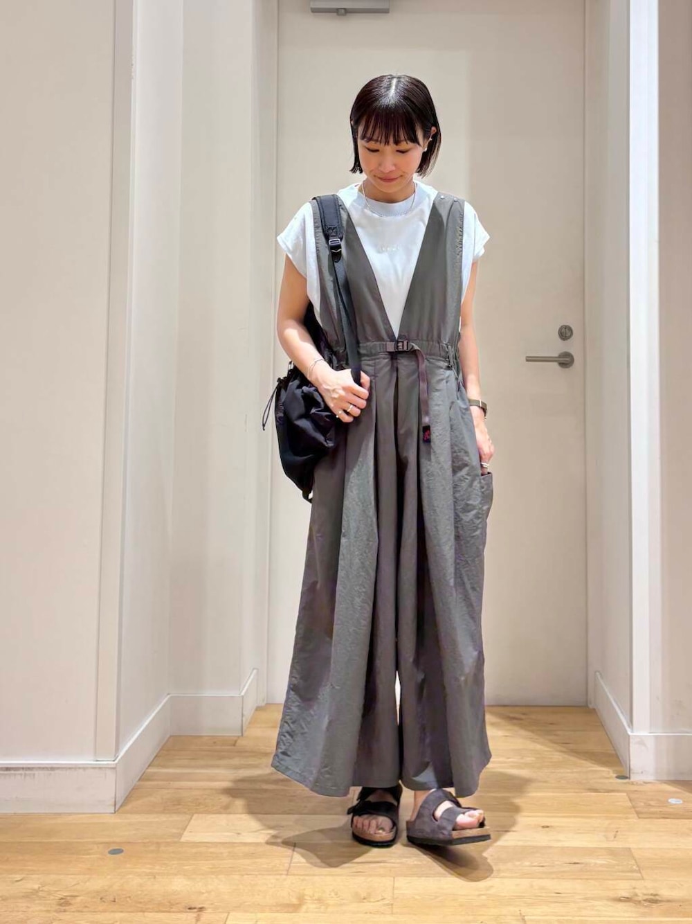 グレー系のサロペット/オーバーオール、ブラック系のバックパック/リュック、ブルー系のTシャツ/カットソーを着用したレディースの夏コーディネートの1枚目の写真