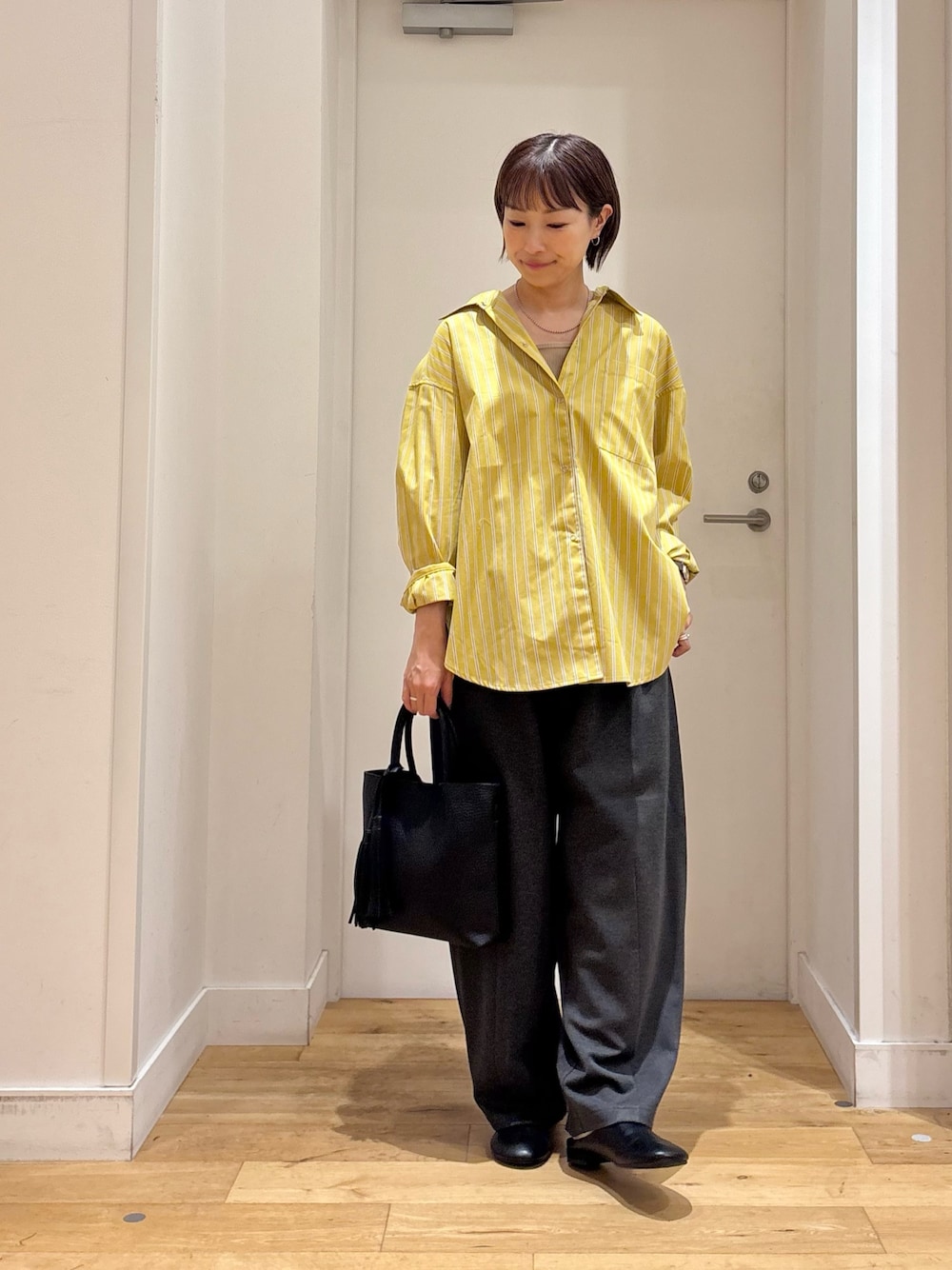イエロー系のシャツ/ブラウス、グレー系のその他パンツ、ベージュ系のタンクトップを着用したレディースの夏コーディネートの1枚目の写真