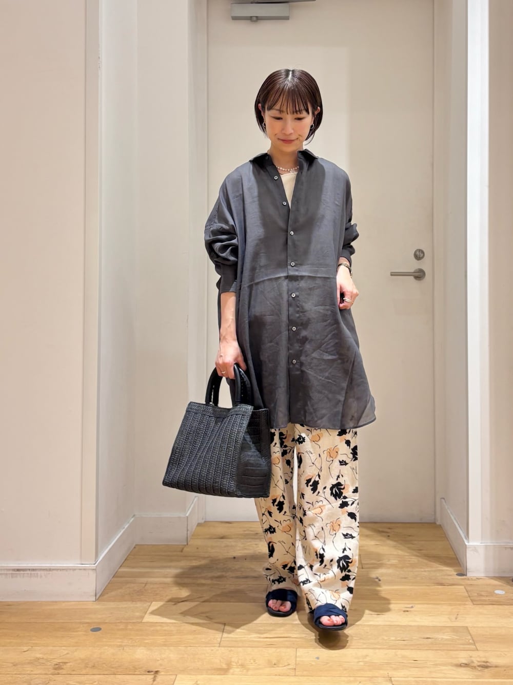 グレー系のシャツ/ブラウス、ベージュ系のその他パンツ、ブラック系のハンドバッグを着用したレディースの春コーディネートの1枚目の写真