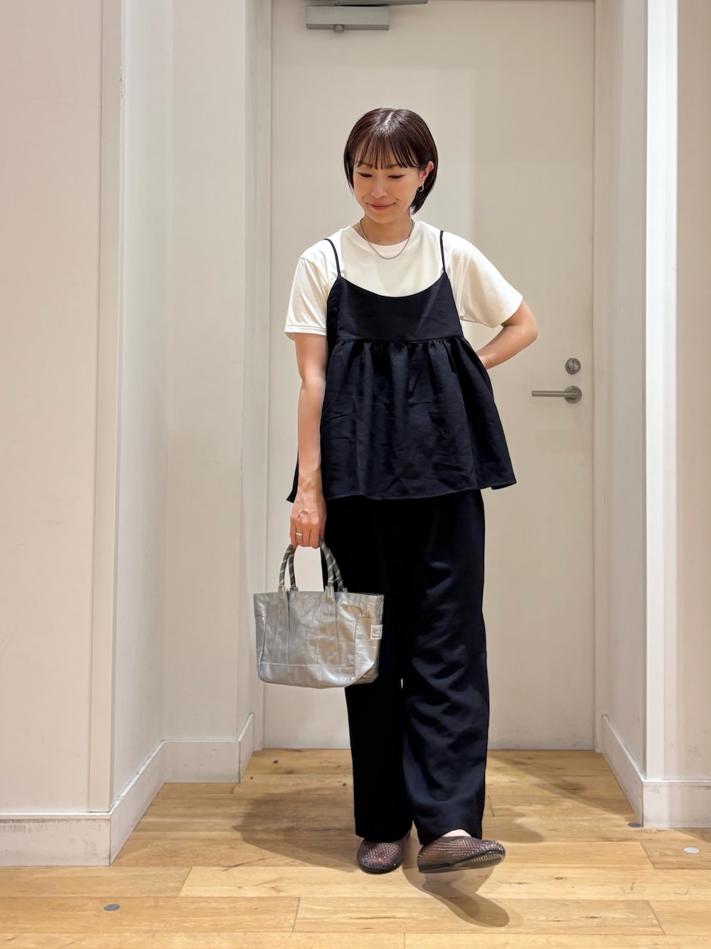 ブラック系のワンピース、ホワイト系のTシャツ/カットソー、シルバー系のショルダーバッグを着用したレディースの夏コーディネートの1枚目の写真