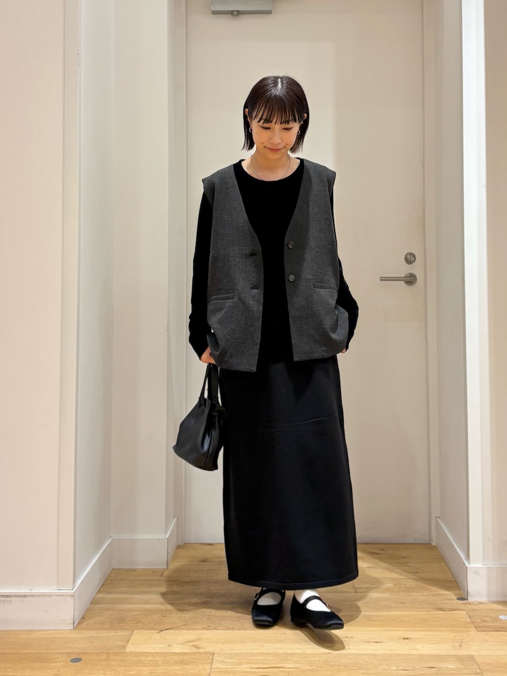 ブラック系のショルダーバッグ、ブラック系のTシャツ/カットソー、ブラック系のその他アウターを着用したレディースの秋コーディネートの1枚目の写真