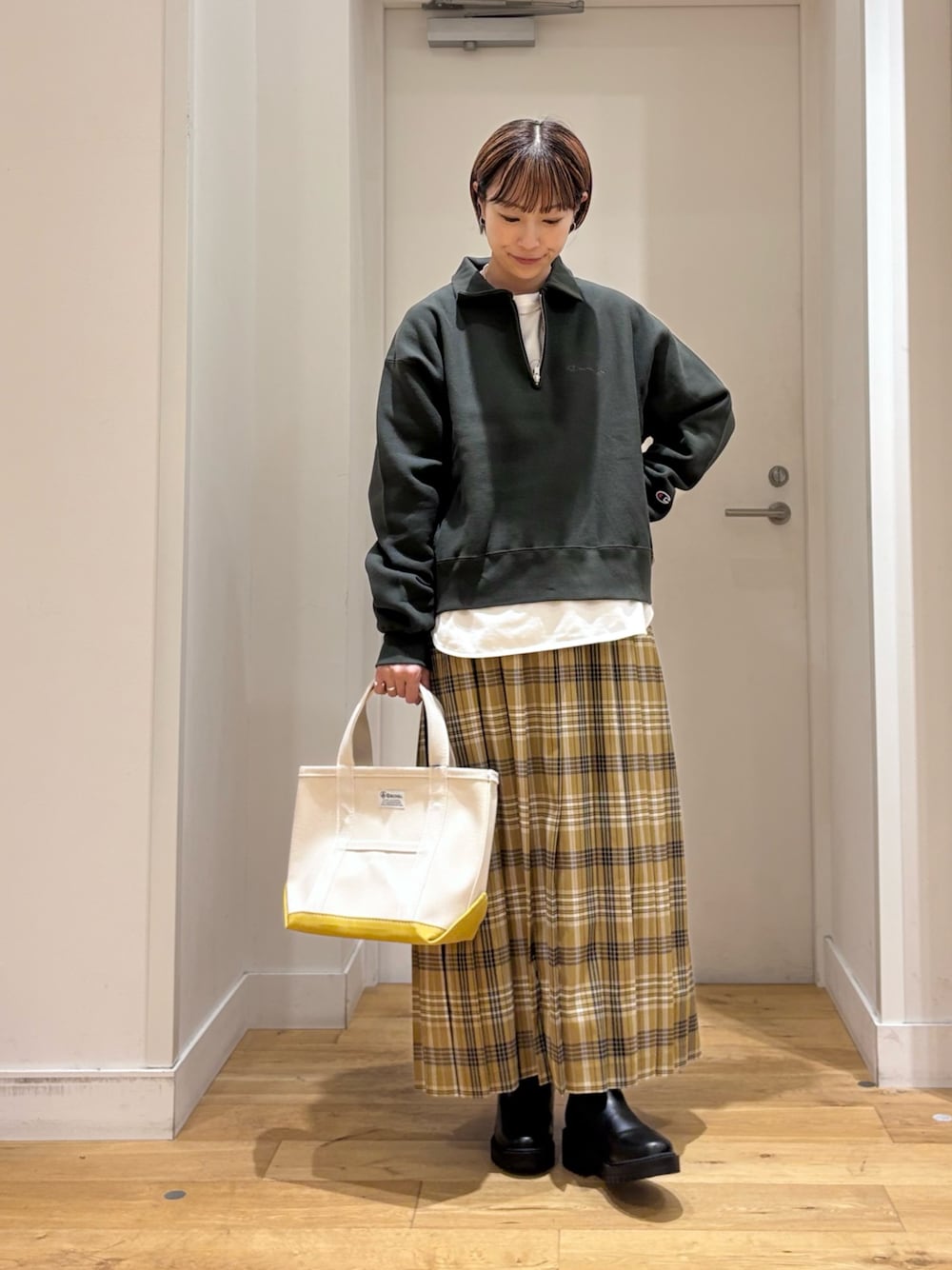 グリーン系のスウェット、イエロー系のスカート、ホワイト系のTシャツ/カットソーを着用したレディースの秋コーディネートの1枚目の写真