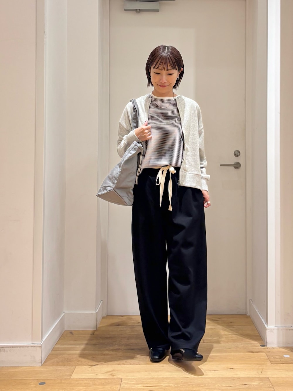 ホワイト系のTシャツ/カットソー、グレー系のカーディガン/ボレロ、ブラック系のその他パンツを着用したレディースの秋コーディネートの1枚目の写真