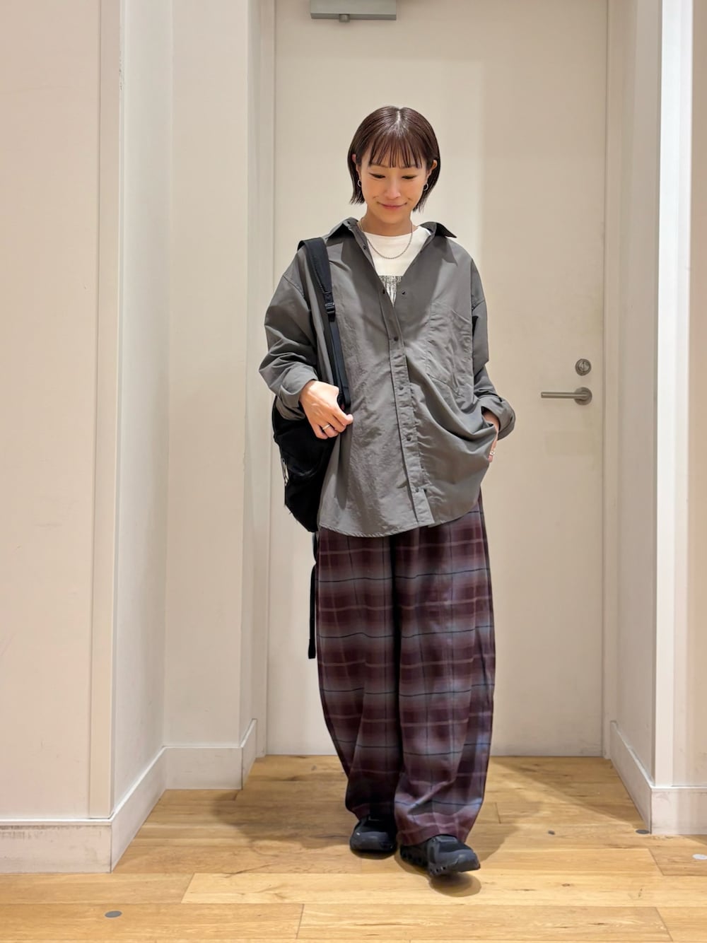 ブラック系のバックパック/リュック、グレー系のシャツ/ブラウス、パープル系のその他パンツを着用したレディースの秋コーディネートの1枚目の写真