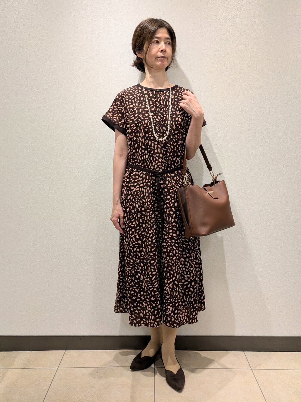 ブラウン系のワンピース、ブラウン系のトートバッグ、ブラウン系のパンプスを着用したレディースの夏コーディネートの1枚目の写真