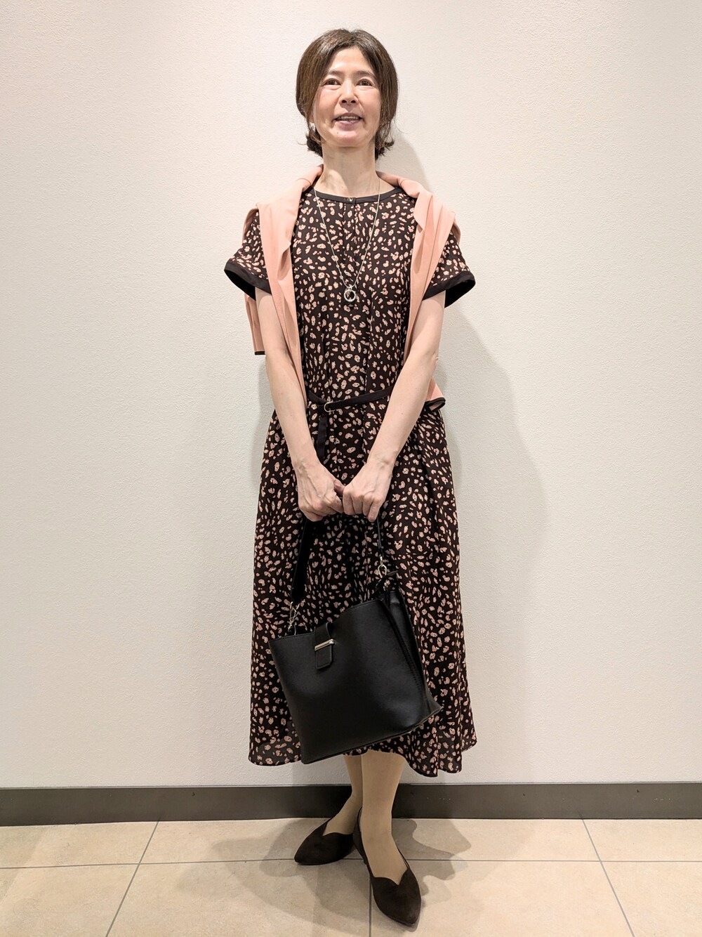 ピンク系のカーディガン/ボレロ、ブラウン系のワンピース、ブラック系のトートバッグを着用したレディースの夏コーディネートの1枚目の写真