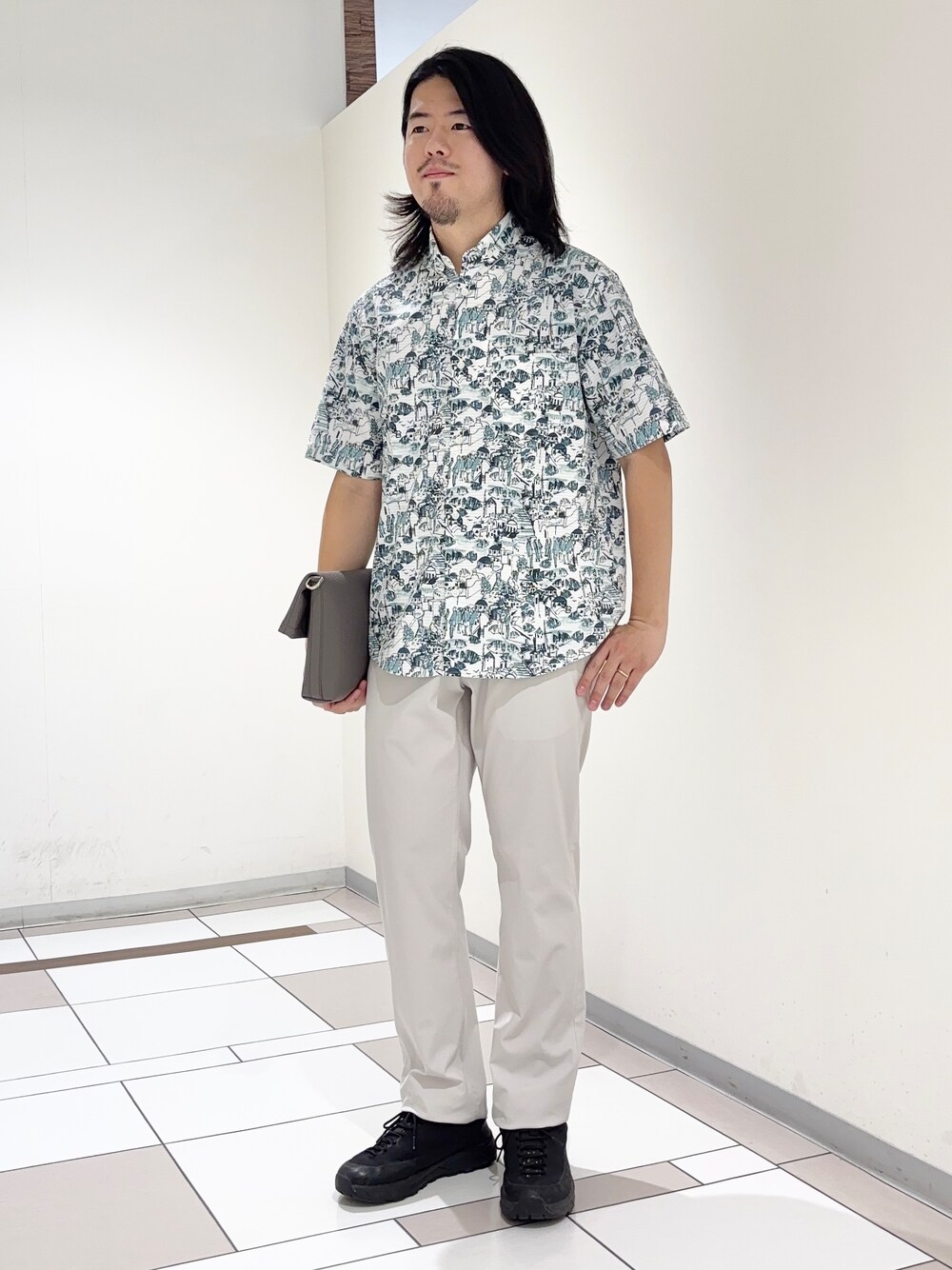 ブルー系のシャツ/ブラウス、ベージュ系のスラックス、グレー系のショルダーバッグを着用したメンズの夏コーディネートの1枚目の写真