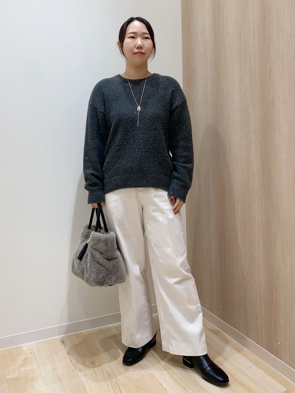 グレー系のニット/セーター、ホワイト系のその他パンツ、グレー系のトートバッグを着用したレディースの冬コーディネートの1枚目の写真