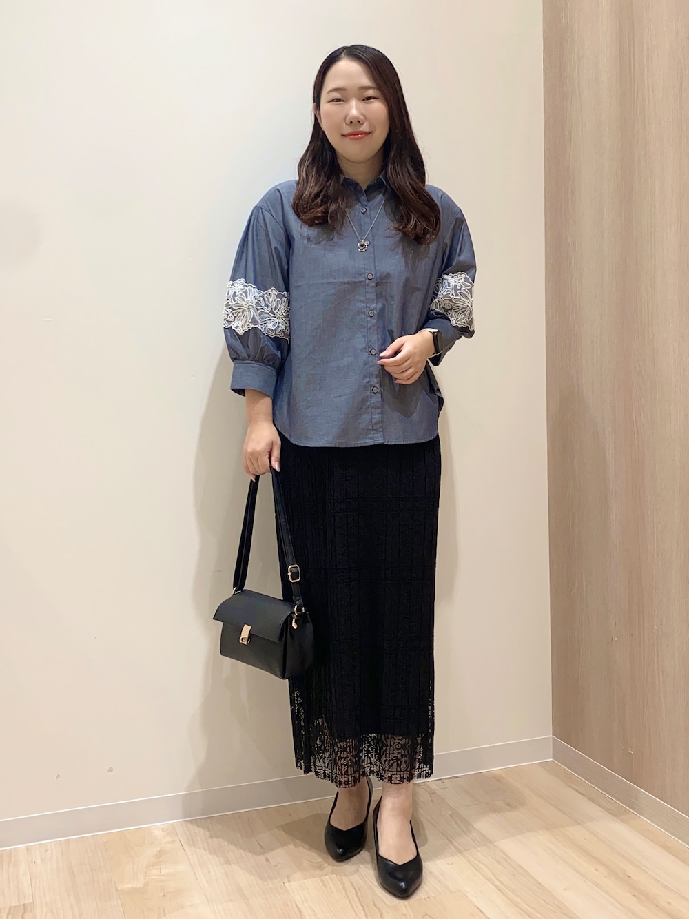 ブルー系のシャツ/ブラウス、ブラック系のスカート、ブラック系のショルダーバッグを着用したレディースの秋コーディネートの1枚目の写真