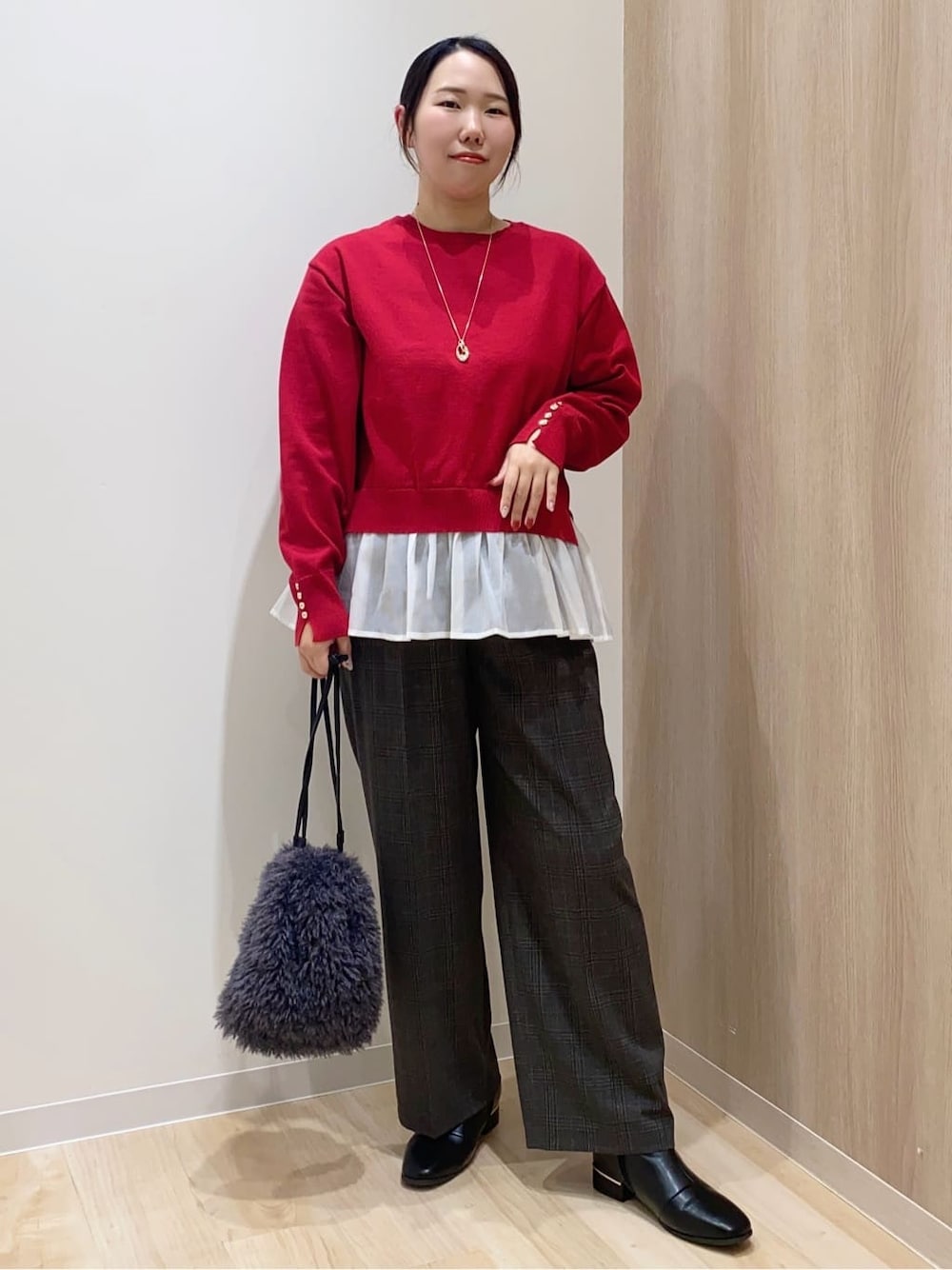 レッド系のニット/セーター、ブラック系のその他パンツ、グレー系のショルダーバッグを着用したレディースの冬コーディネートの1枚目の写真
