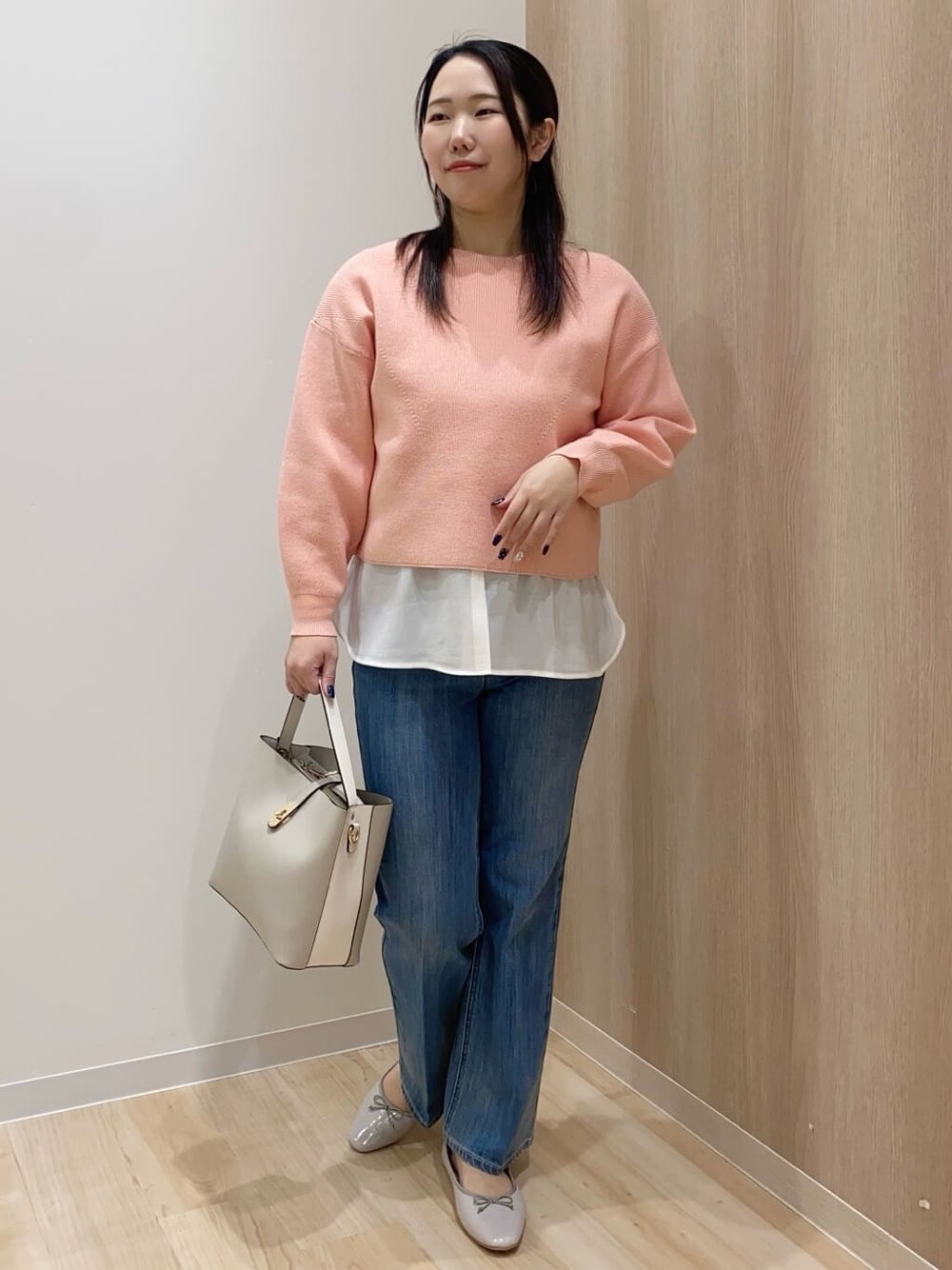 ピンク系のニット/セーター、ホワイト系のTシャツ/カットソー、ブルー系のデニムパンツを着用したレディースの冬コーディネートの1枚目の写真