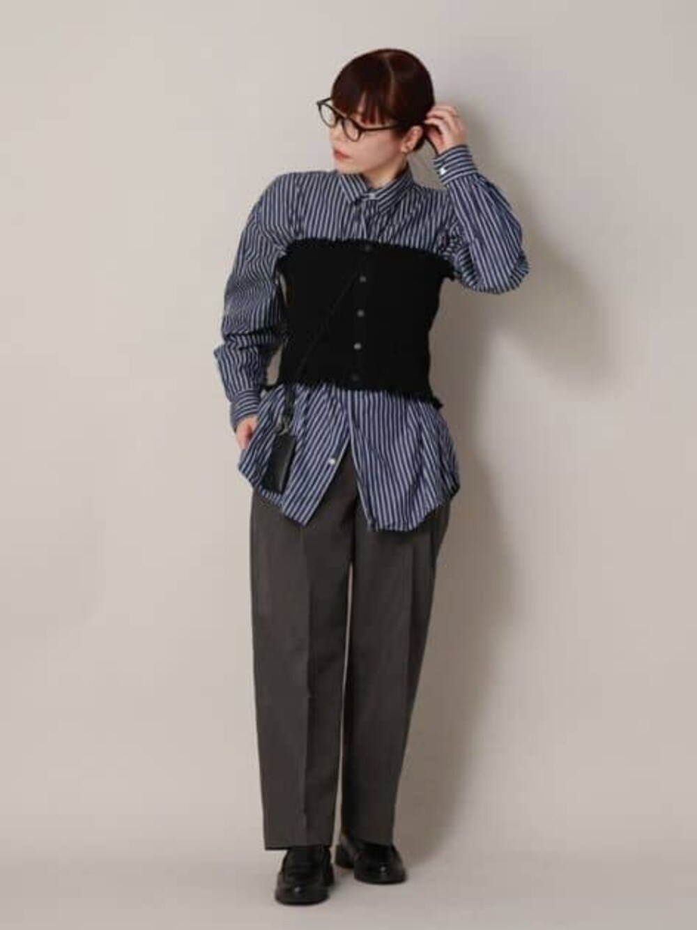 ブラック系のシャツ/ブラウス、グレー系のスラックスを着用したレディースの冬コーディネートの1枚目の写真
