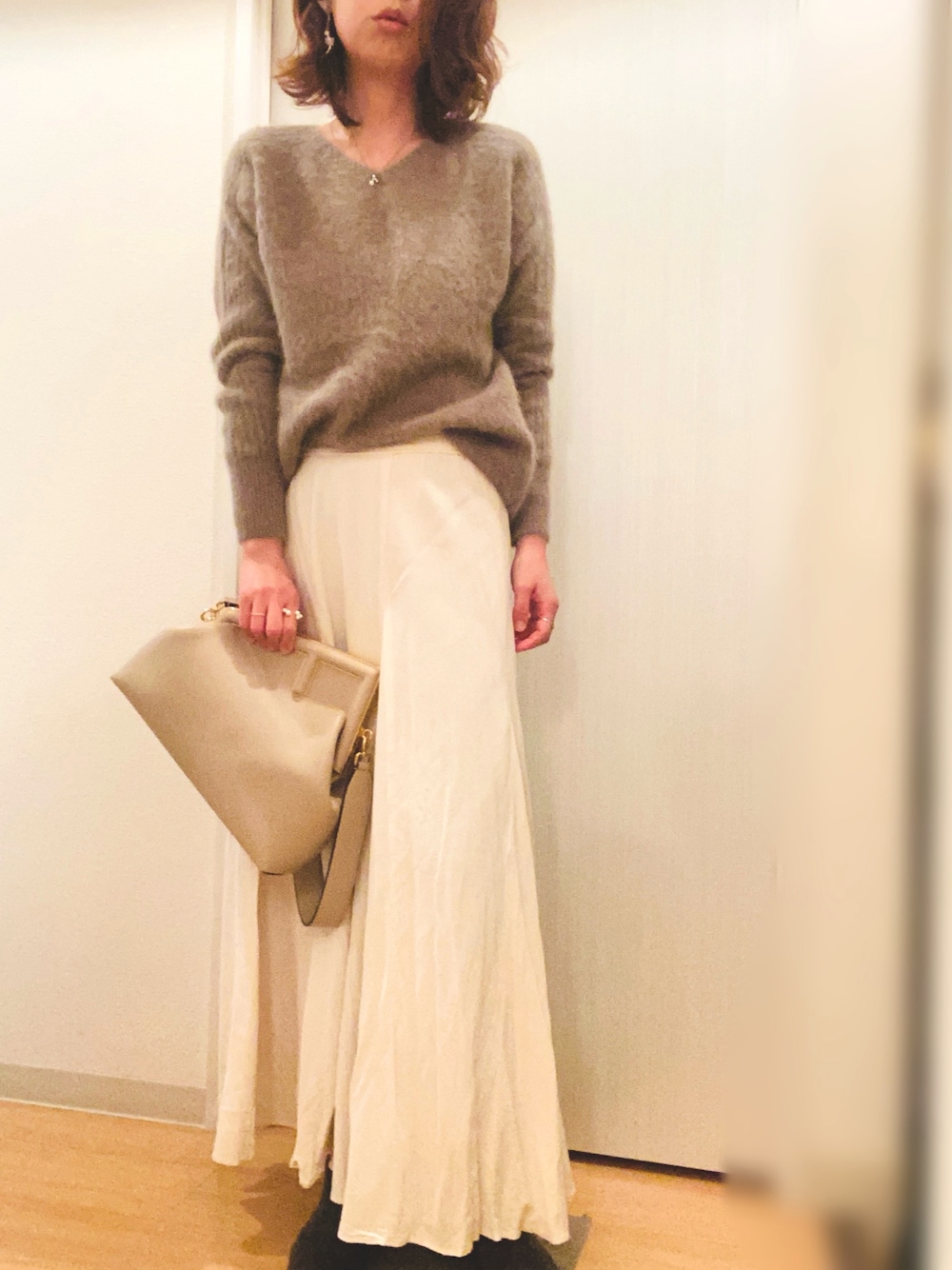 ブラウン系のニット/セーター、ホワイト系のスカート、ブラウン系のその他アウターを着用したレディースの冬コーディネートの1枚目の写真