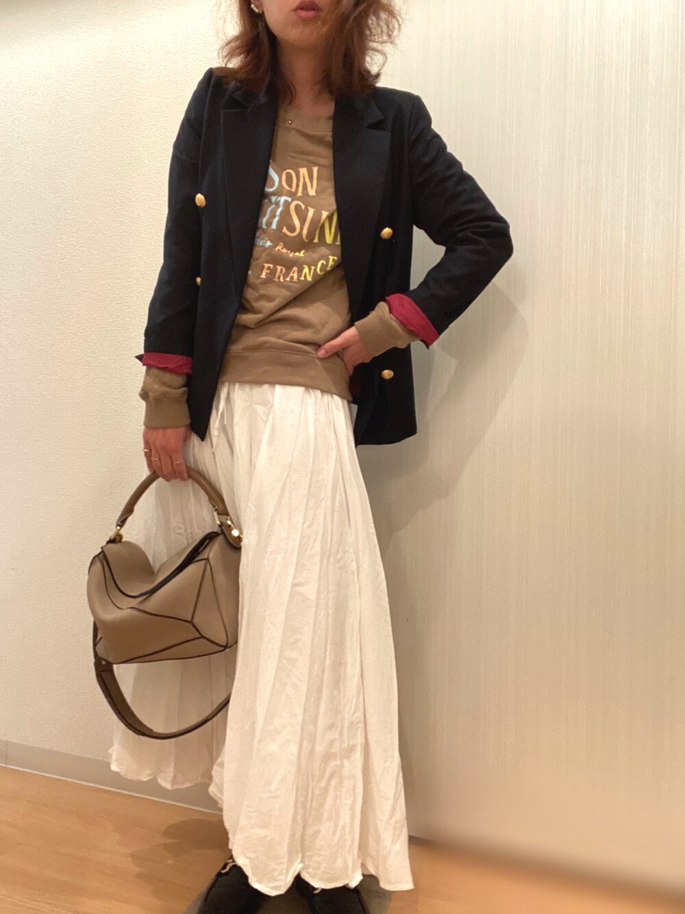 グリーン系のスウェット、ブルー系のテーラードジャケット、ホワイト系のスカートを着用したレディースの秋コーディネートの1枚目の写真