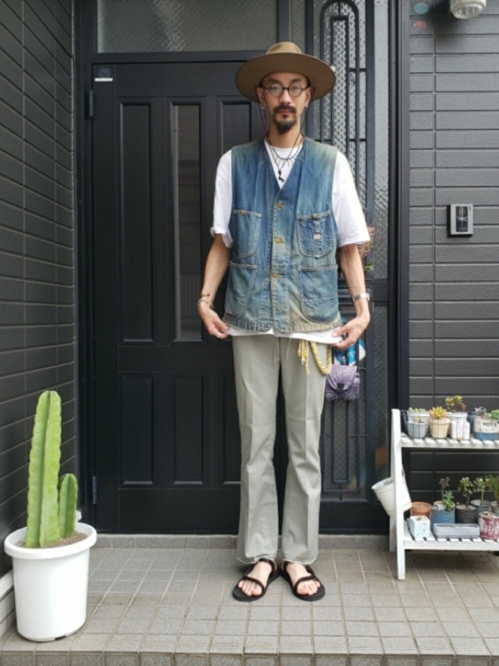 ブルー系のベスト、ホワイト系のTシャツ/カットソー、ベージュ系のスラックスを着用したメンズの夏コーディネートの1枚目の写真