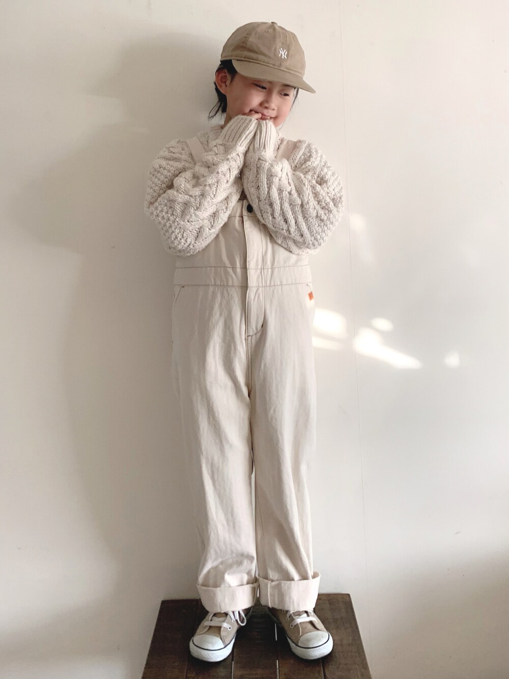 「クリスマスに着たい服、ホワイトコーデ、シンプルコーデ、ケーブルニット、ニット、サロペット、オーバーオール、キャップ、ハイカットスニーカー、コンバース、スニーカー、冬コーデ」｜「antiquaのニット（ニット/セーター、ベージュ系）」を使った、bow-changさん（キッズ・120cm）の冬コーディネートの1枚目の写真