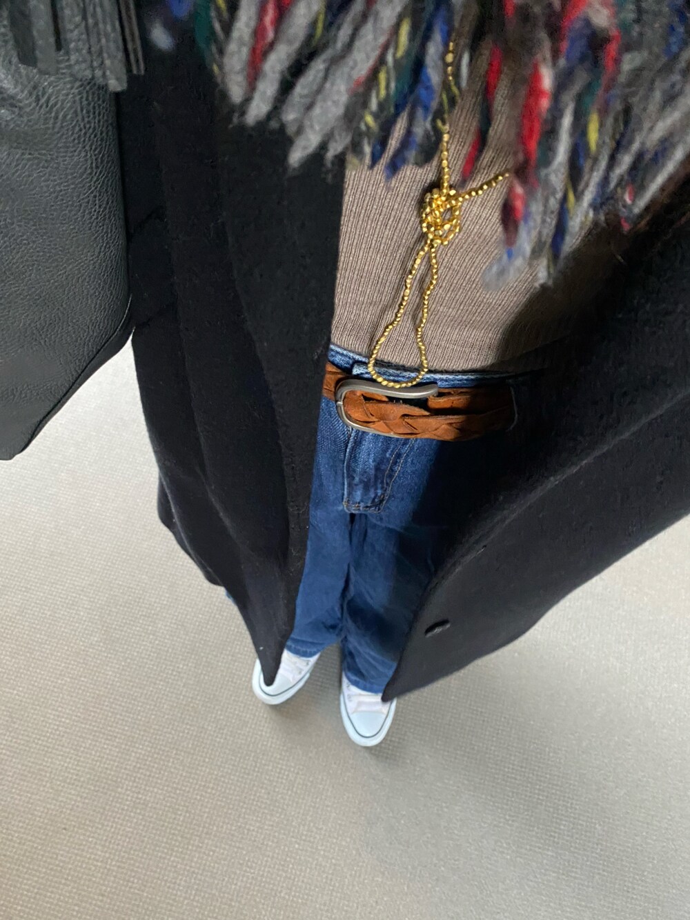 ホワイト系のスニーカー、ブルー系のデニムパンツ、ベージュ系のニット/セーターを着用したレディースの冬コーディネートの1枚目の写真