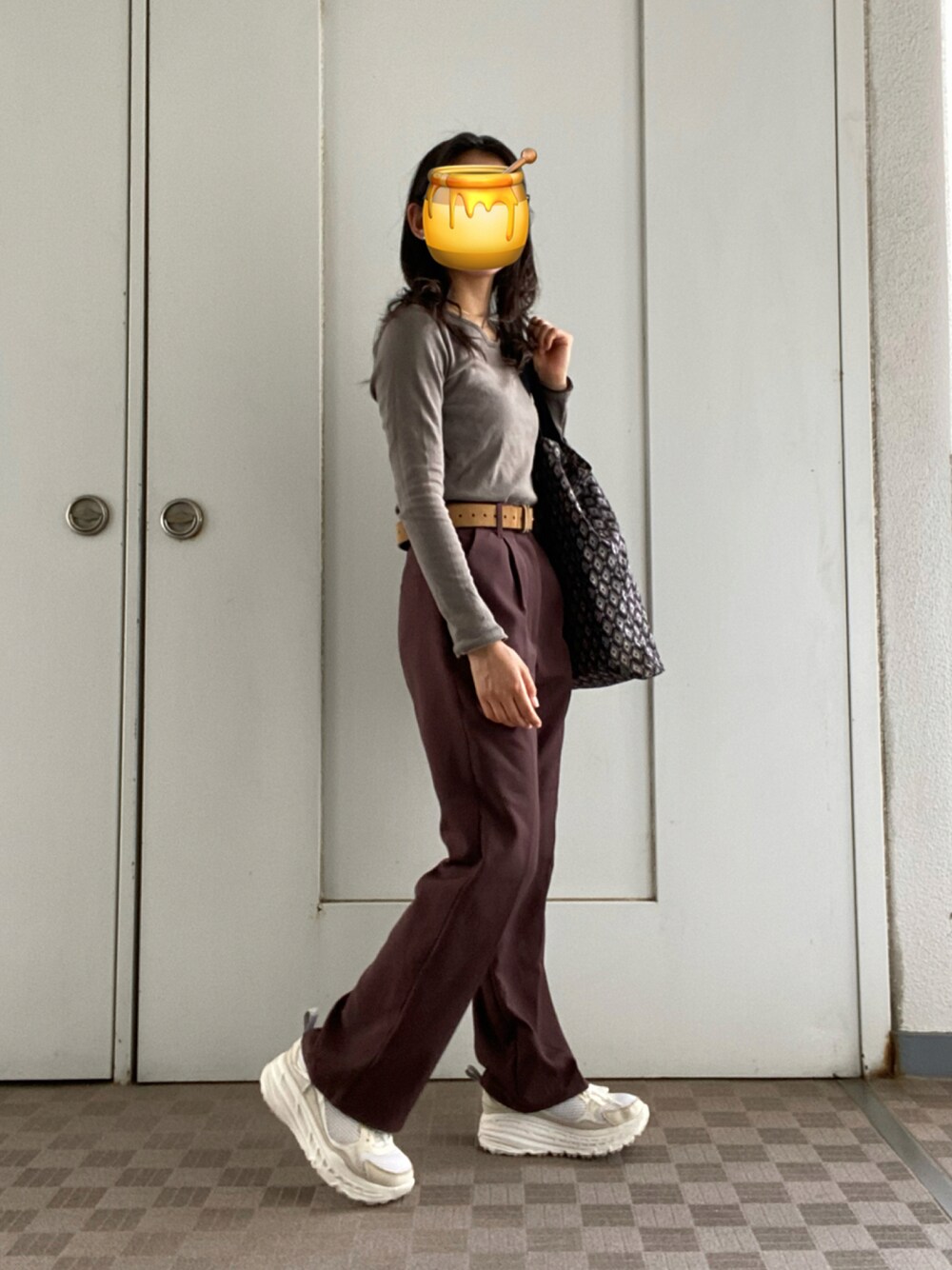 ブラウン系のスラックス、ベージュ系のTシャツ/カットソー、ホワイト系のスニーカーを着用したレディースの秋コーディネートの1枚目の写真