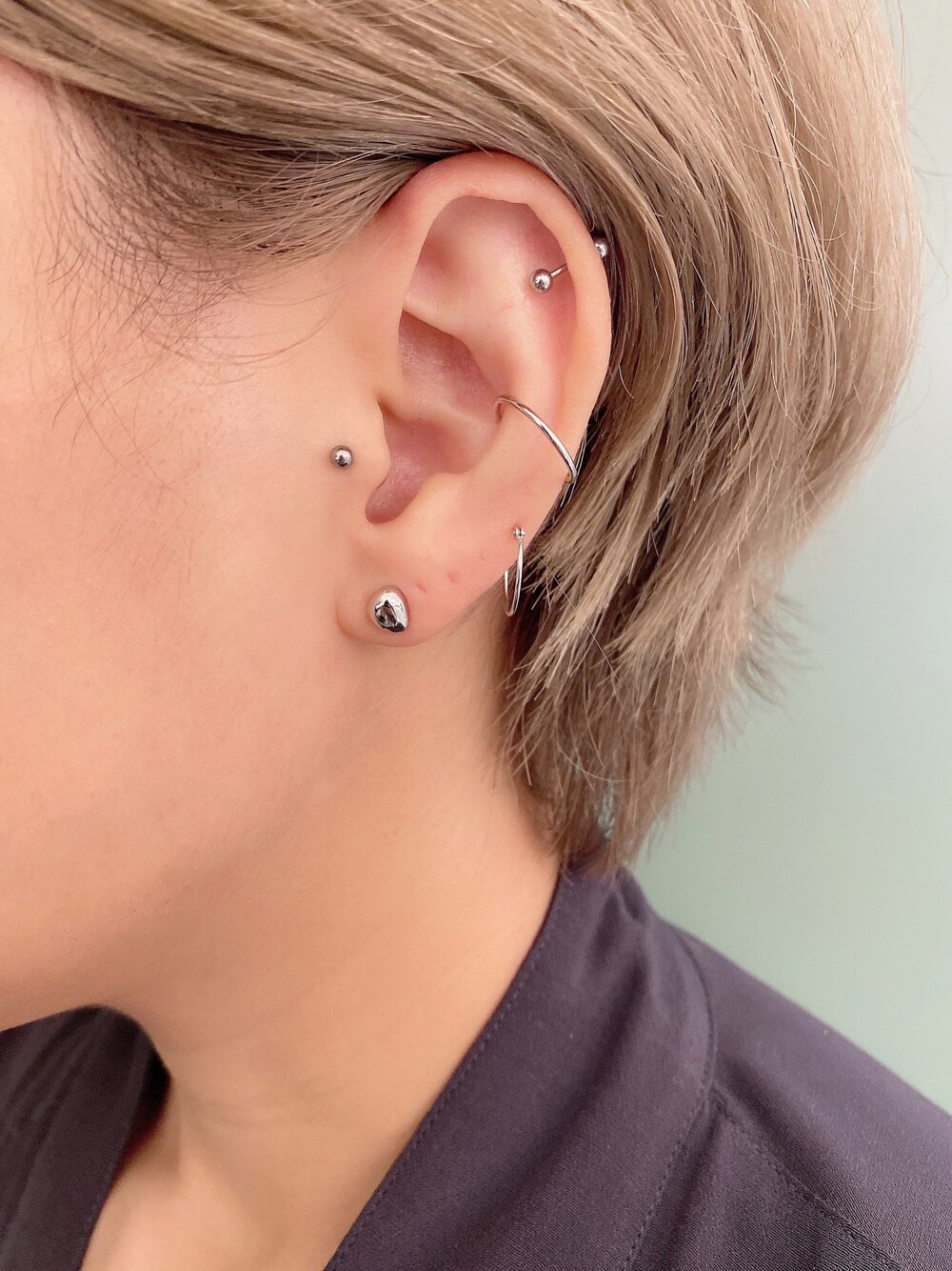 シルバー系のピアス（片耳用）、ゴールド系のピアス（両耳用）、ゴールド系のイヤーカフを着用したレディースの夏コーディネートの1枚目の写真