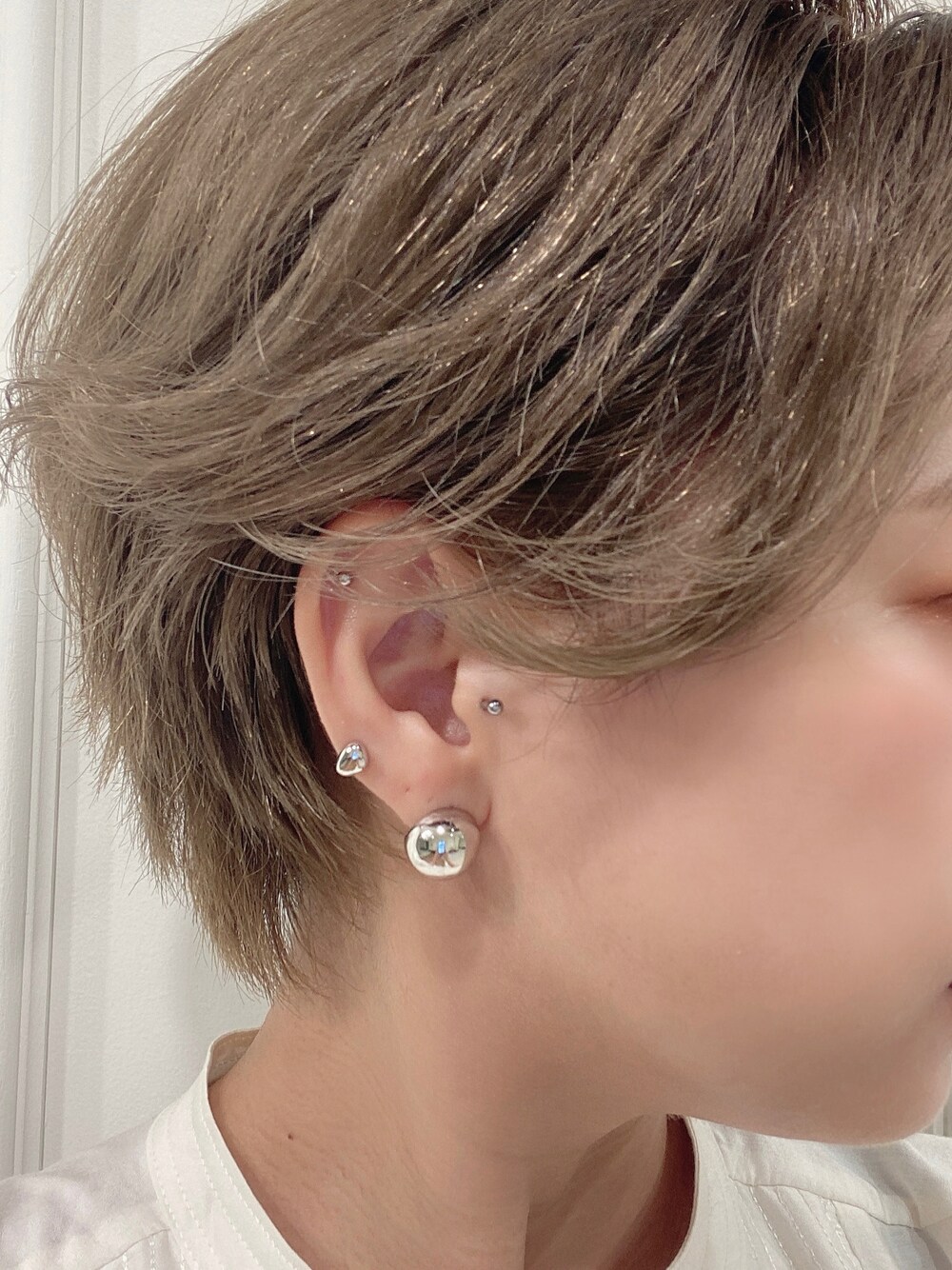 シルバー系のピアス（両耳用）、シルバー系のピアス（片耳用）を着用したレディースの夏コーディネートの1枚目の写真