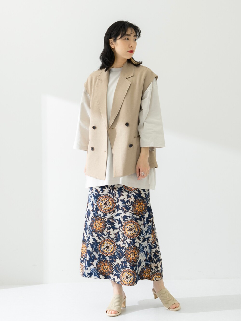 ベージュ系のTシャツ/カットソー、ベージュ系のその他アウター、ホワイト系のサンダルを着用したレディースの春コーディネートの1枚目の写真