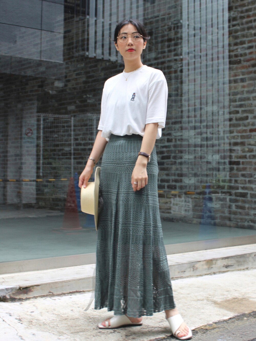 ホワイト系のTシャツ/カットソー、グリーン系のスカート、ホワイト系のサンダルを着用したレディースの夏コーディネートの1枚目の写真