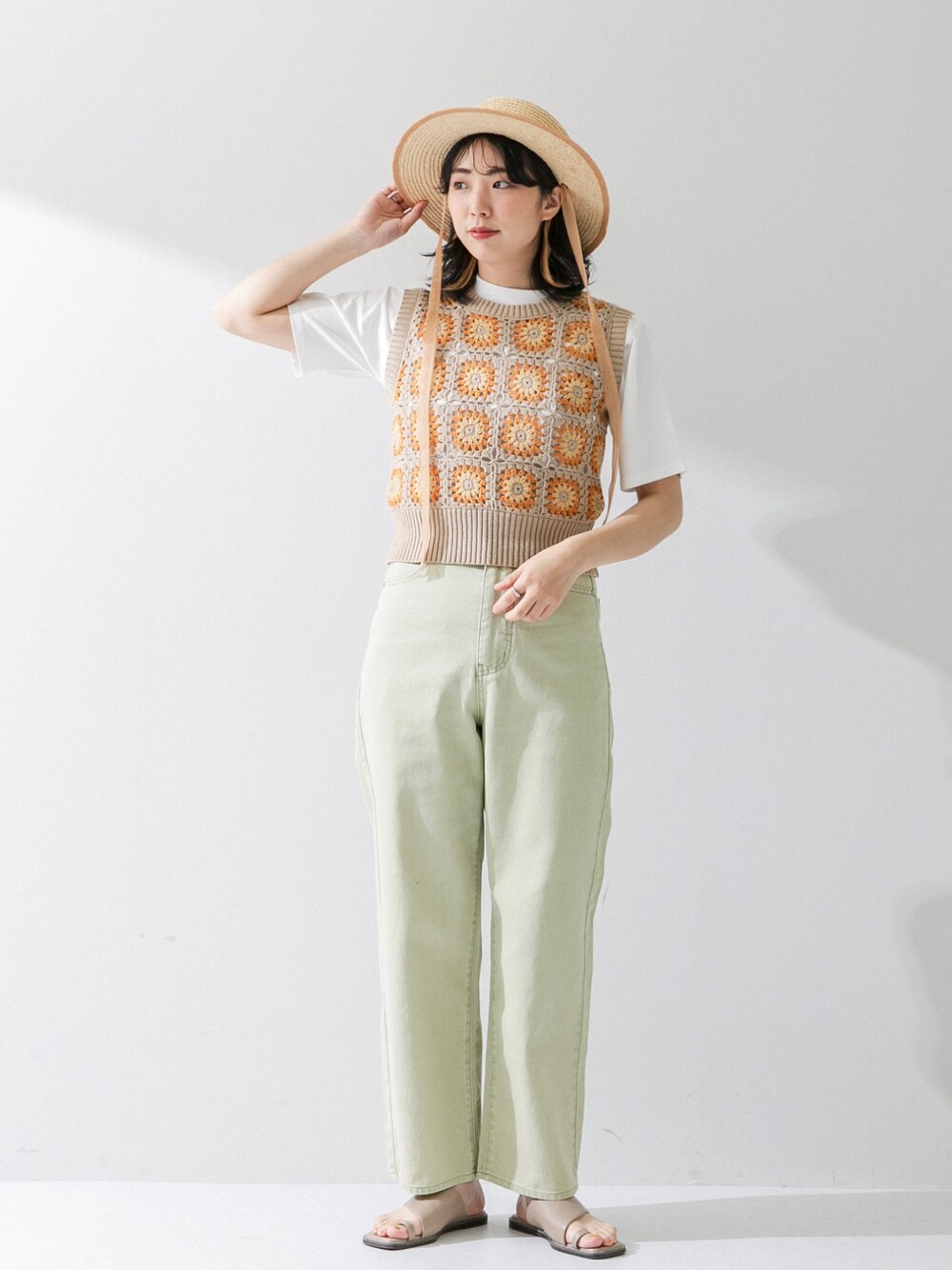 ベージュ系のベスト、グリーン系のデニムパンツ、ホワイト系のTシャツ/カットソーを着用したレディースの春コーディネートの1枚目の写真