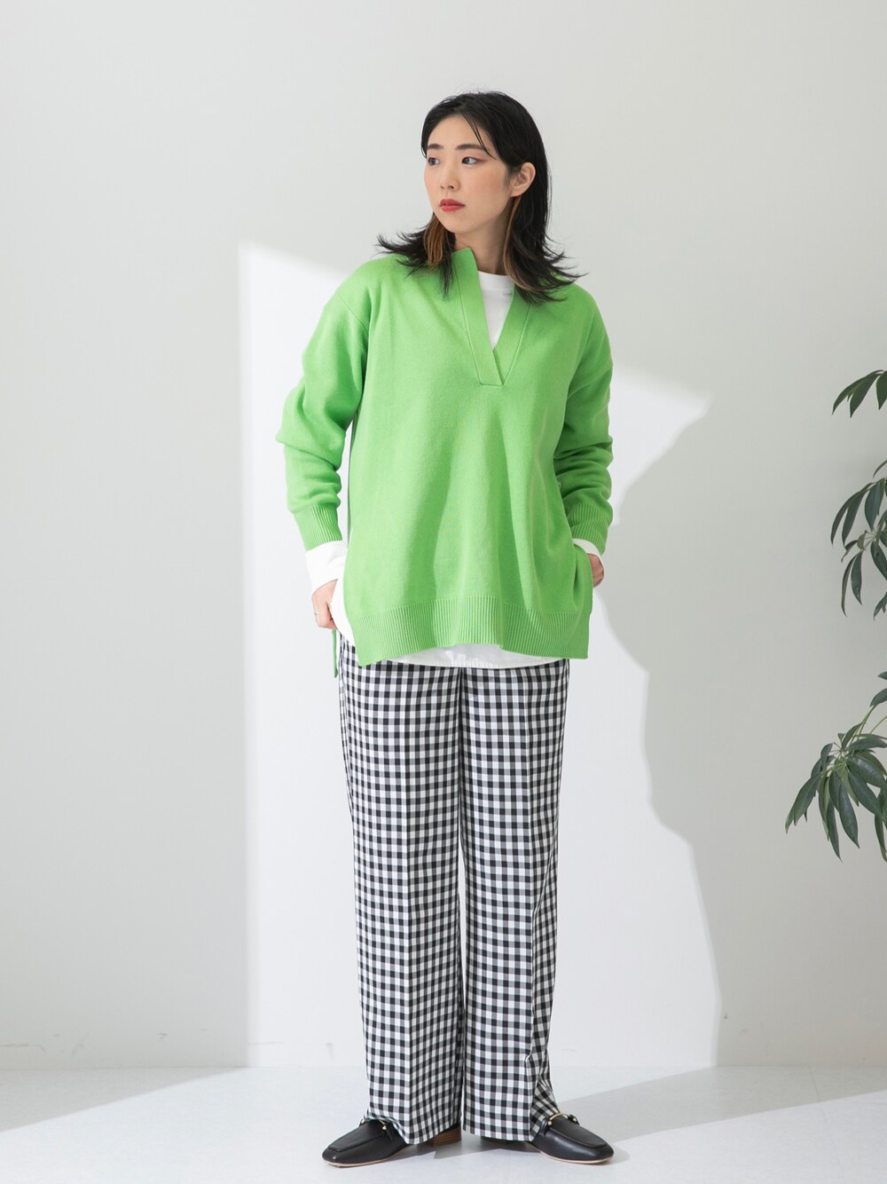 グリーン系のニット/セーター、ホワイト系のTシャツ/カットソー、ブラック系のローファーを着用したレディースの春コーディネートの1枚目の写真